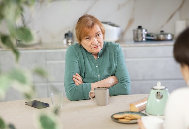 elderly lady at table with cup of coffee